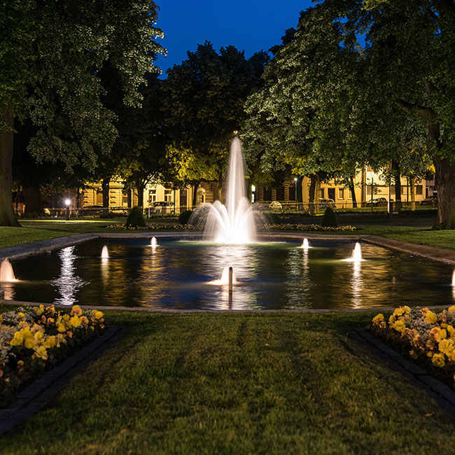 Fontaine illuminée de nuit dans parc en ville